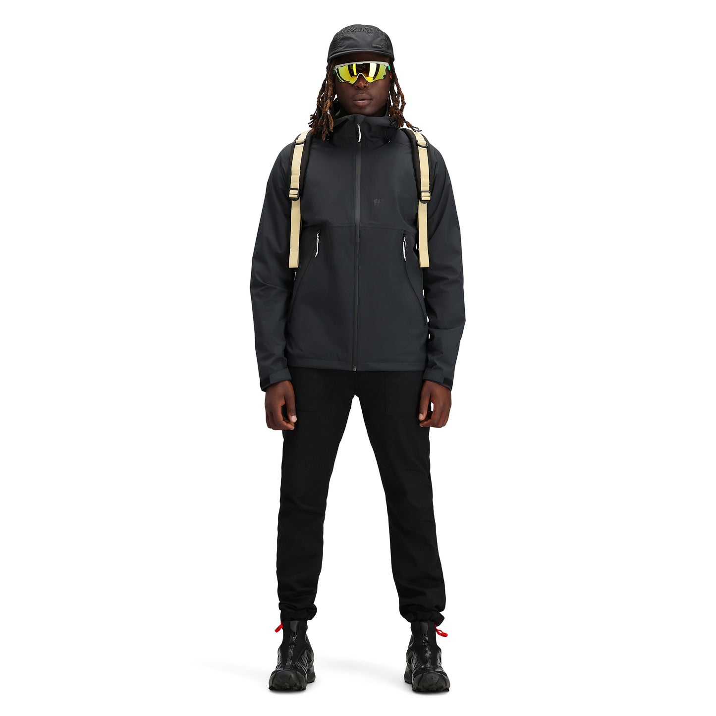 Model wearing Topo Designs Men's Global Jacket packable 10k waterproof rain shell in recycled "black" polyester.