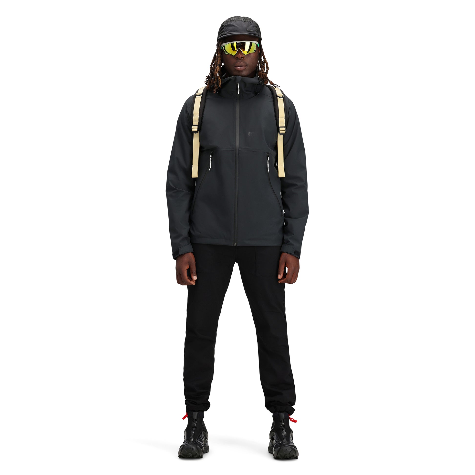 Model wearing Topo Designs Men's Global Jacket packable 10k waterproof rain shell in recycled "black" polyester.